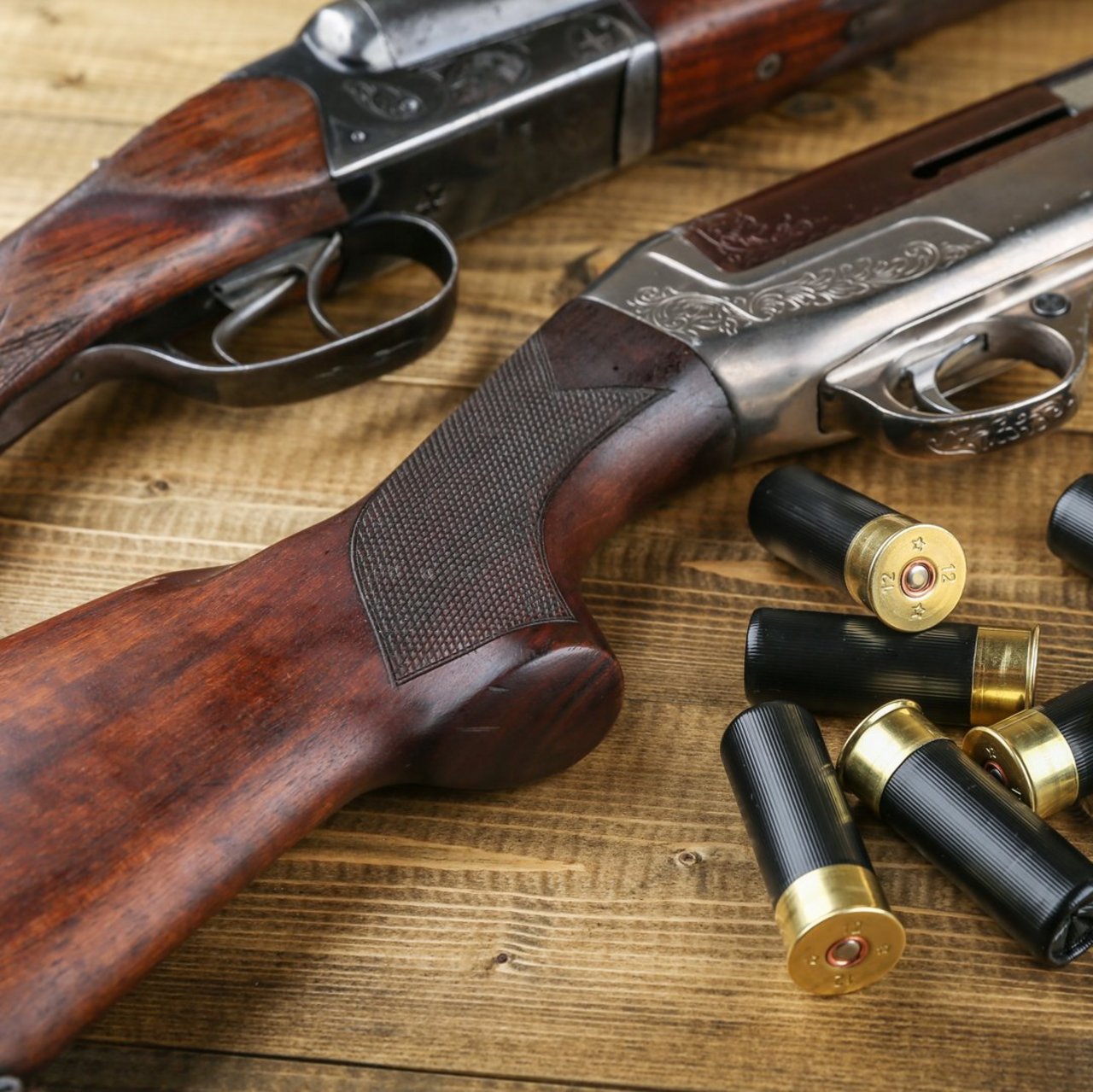hunting rifles and cartridges are on wooden background, studio photo shot. hunter guns and bullets close up